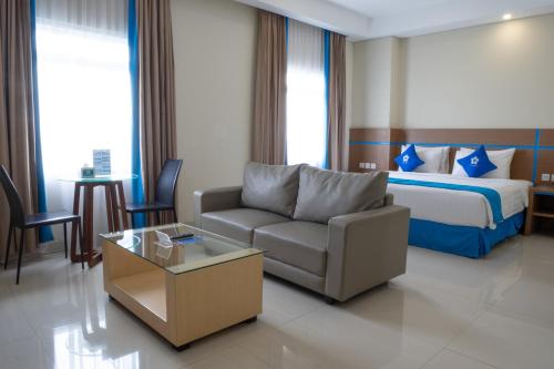 a hotel room with a couch and a bed at Hotel Brothers Solo in Solo