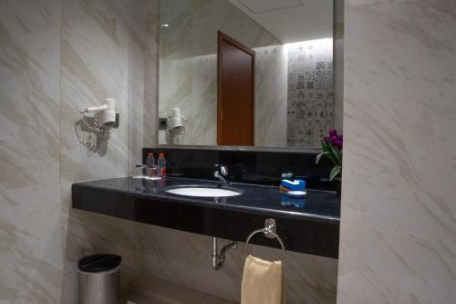 a bathroom with a sink and a mirror at Hotel Brothers Solo in Solo