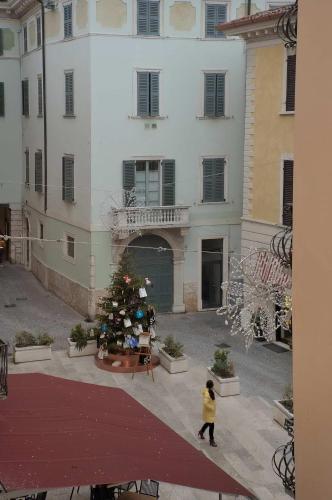 a person walking in front of a building with a christmas tree at Antico Teatro signorile in Salò