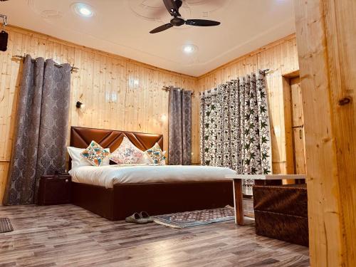a bedroom with a bed in a room with wooden walls at The Routes Pahalgam in Kolur