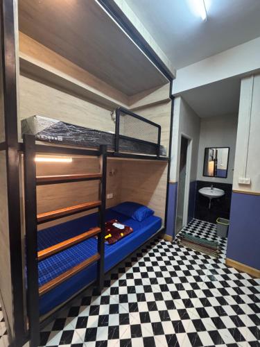 a bunk bed in a room with a checkered floor at WannaB Hostel in Khlong San