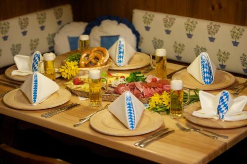 a wooden table with plates and napkins andbeer bottles at AktiVital Hotel in Bad Griesbach