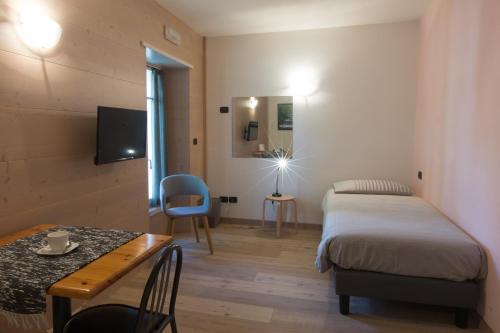 a small room with a bed and a table and a tableablish at Marzia Rooms in Bormio