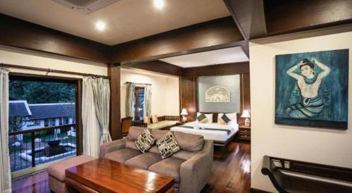 ein Wohnzimmer mit Sofa und Bett in der Unterkunft Wiangkaew Hotel in Ban Fai Kaeo