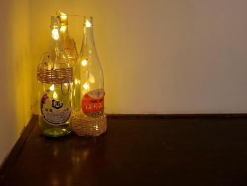 two bottles with lights on top of a table at ゲストハウス真鶴の家-Guest House Manazuru House in Manazuru