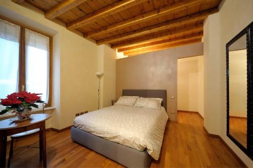 a bedroom with a bed and a table and window at Antico Teatro signorile in Salò