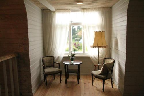 a room with two chairs and a table and a window at Meke in Mustkalni