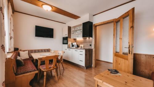 a living room with a table and a kitchen at Posers Bergwelt B&B in Schladming