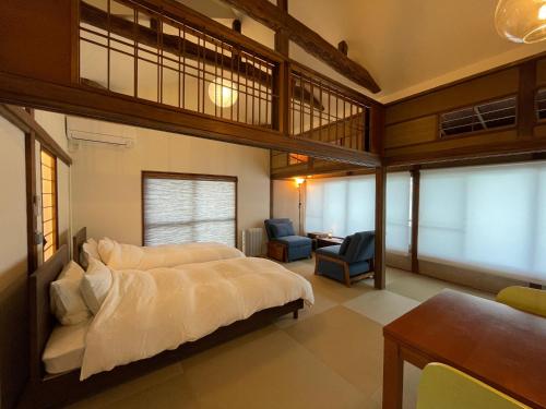 a bedroom with a large bed and a desk and chair at ゲストハウス真鶴の家-Guest House Manazuru House in Manazuru