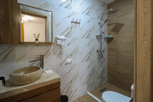 een badkamer met een wastafel en een spiegel bij Gudauri Star in Goedaoeri