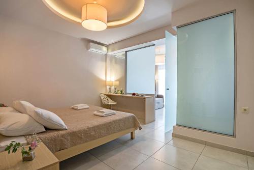 ein Schlafzimmer mit einem Bett und einem großen Fenster in der Unterkunft Apollo Hotel 1 in Georgioupoli