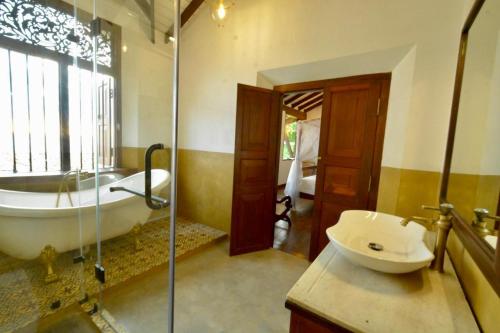 a bathroom with a tub and a toilet and a sink at Agni Luxury Beach Villa in Olagama