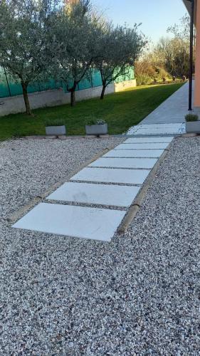 a stone walkway in a park with trees and a building at Agriturismo Ai Progni in Affi