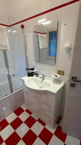 a bathroom with a white sink and a red and white floor at D'Aversa Rooms in Marineo