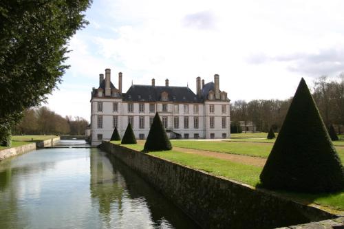 a large stone building with a boat in front of it at Château-Hôtel de Bourron in Bourron-Marlotte