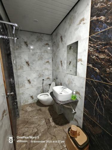 a bathroom with a sink and a toilet at Vrindavan beach resort in Diveagar