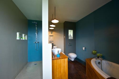 een badkamer met een bad, een toilet en een wastafel bij Château de Baylac in Bugnein