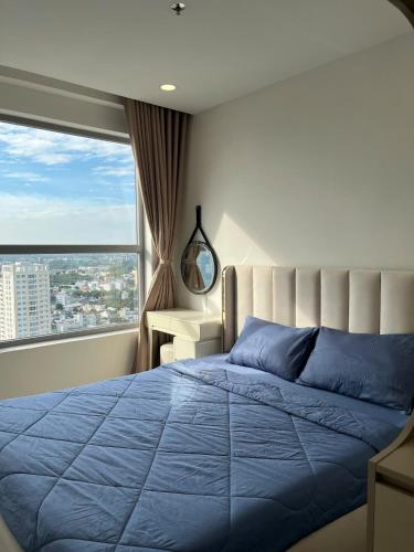 a bedroom with a blue bed and a window at HongHome Happy One Central in Ga Phú Văn