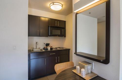 a kitchen with a table and a sink and a mirror at Studio 6-Concord, CA in Concord