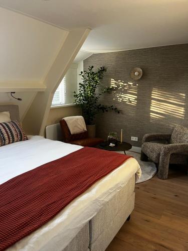 una camera da letto con un letto, un tavolo e delle sedie di Puur Schoorl a Schoorl