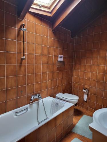 een badkamer met een ligbad en een toilet bij skyview house in Delfoi