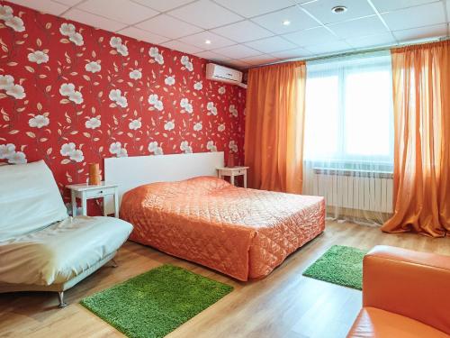 モスクワにあるHotel Bonjour Butovoの赤い壁のベッドルーム1室(ベッド2台付)