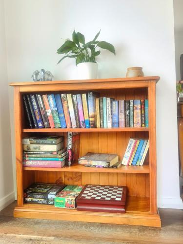 a book shelf filled with books and a plant at Christian's Minde Jervis bay in Jervis Bay Village