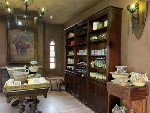 a room with a large wooden book shelf and a table at Castle de Wildt in Modimolle