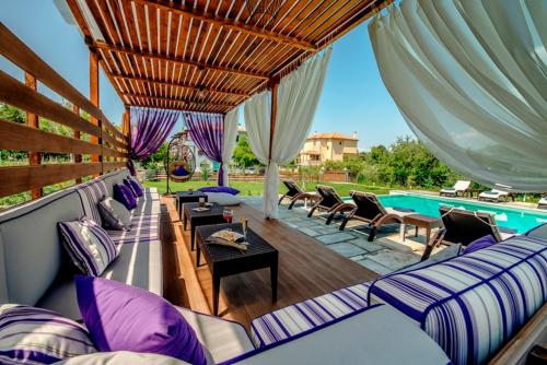 a patio with couches and a swimming pool at Levantes Villas in Kala Nera