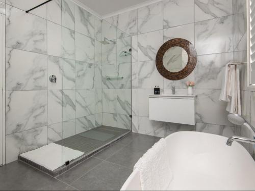 een badkamer met een douche met een glazen deur bij Absolute Ocean Boutique Guesthouse in Hermanus