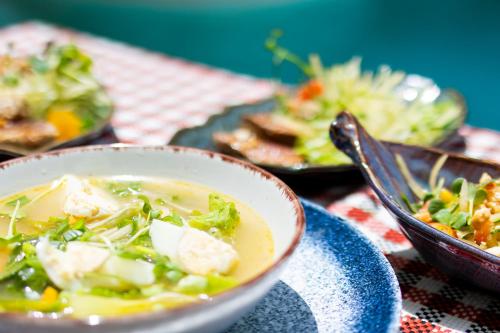 eine Schüssel Suppe auf einem Tisch mit anderen Tellern. in der Unterkunft ZAN Tropical Jambiani Beach in Bwejuu