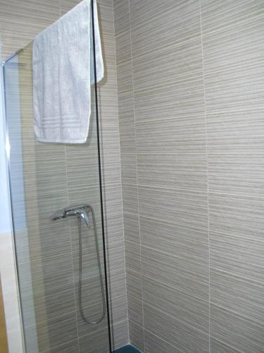 a shower stall with a glass door with a white towel at La Candela in Rabanal del Camino