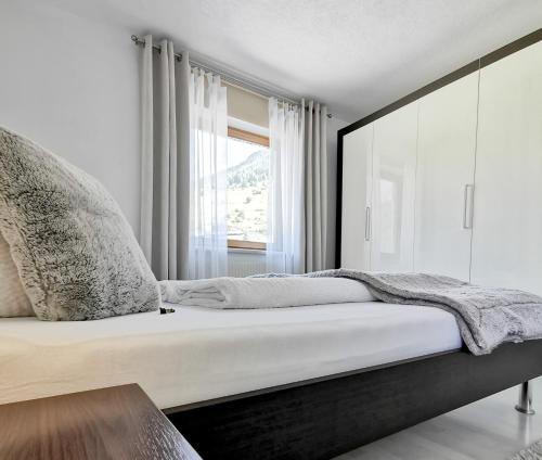 una camera da letto con un letto grande con una finestra di das Alpenblick & Outdoor Lodge Nauders a Nauders