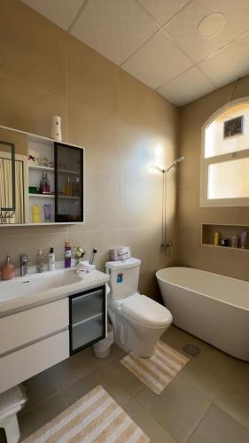 a bathroom with a tub and a toilet and a sink at The Moonridge Retreat in Sinādil