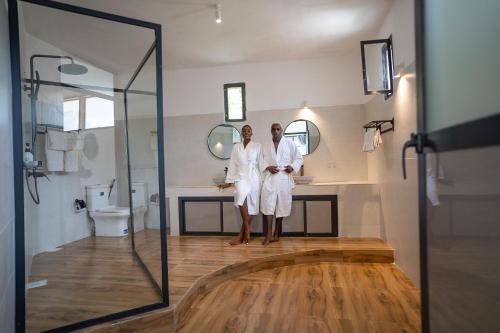 zwei Frauen in weißen Roben stehen im Badezimmer in der Unterkunft ZAN Tropical Jambiani Beach in Bwejuu
