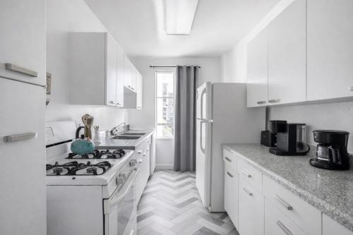 a white kitchen with a stove and a refrigerator at Spacious 2 Bedroom 2 Bathroom Unit Great Location in Los Angeles