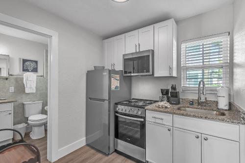 a kitchen with a stainless steel refrigerator and a sink at The Bungalows in St. Pete Beach
