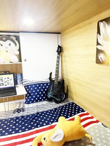 Un dormitorio con una bandera estadounidense y una guitarra. en urban studios, en Phnom Penh