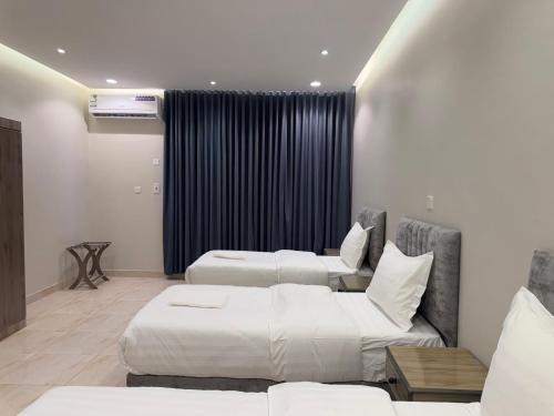 een hotelkamer met twee bedden en een bank bij ركن صحاري للشقق المخدومة ضبا Rukn Sahari for Served Apartments in Ḑubā