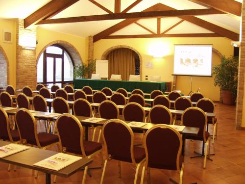 a conference room with tables and chairs and a screen at Il Carrettino Country Hotel in Tortona