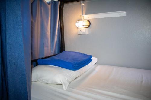 a small room with a bed with a blue curtain at Revolution Pai In Town in Pai