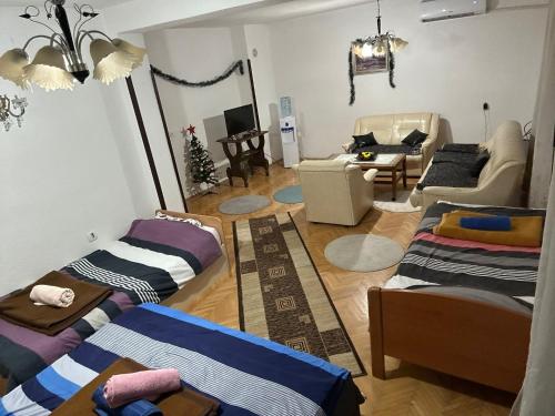 een woonkamer met 3 bedden en een bank bij Apartman Struga in Struga
