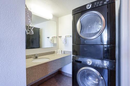 a bathroom with a washer and dryer next to a sink at Motel 6-Williams, AZ - West - Grand Canyon in Williams