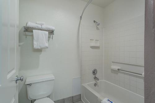 a white bathroom with a toilet and a bath tub at Motel 6-Williams, AZ - West - Grand Canyon in Williams