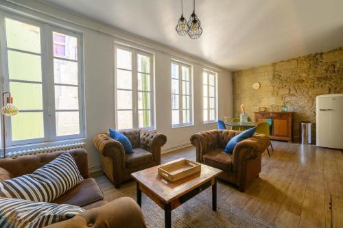a living room with couches and a table at Votre famille à Périgueux Charme & Confort in Périgueux