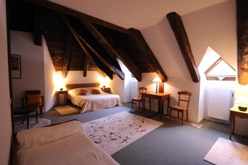 ein Schlafzimmer mit einem Bett, zwei Fenstern und einem Sofa in der Unterkunft Domaine du Lac Ferrand in Saint-Cirgues-en-Montagne