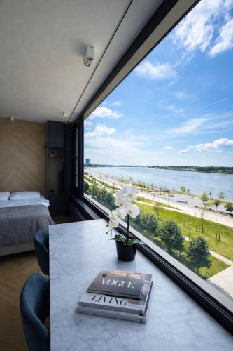 a room with a table with a view of the ocean at SLEEP INN - Kaai11, Riverview Lofts & Suites in Antwerp