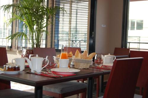 a dining room table with food on top of it at Plessis Parc Hôtel in Le Plessis-Robinson