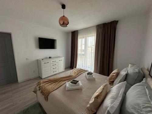 a bedroom with a large bed and a television at ZenHome in Craiova