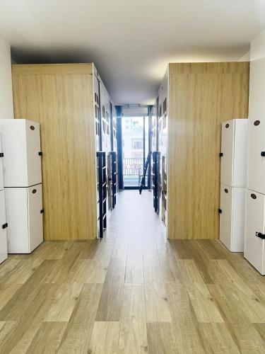 Una habitación vacía con puertas de madera y refrigeradores en una habitación con pisos de madera. en urban studios, en Phnom Penh